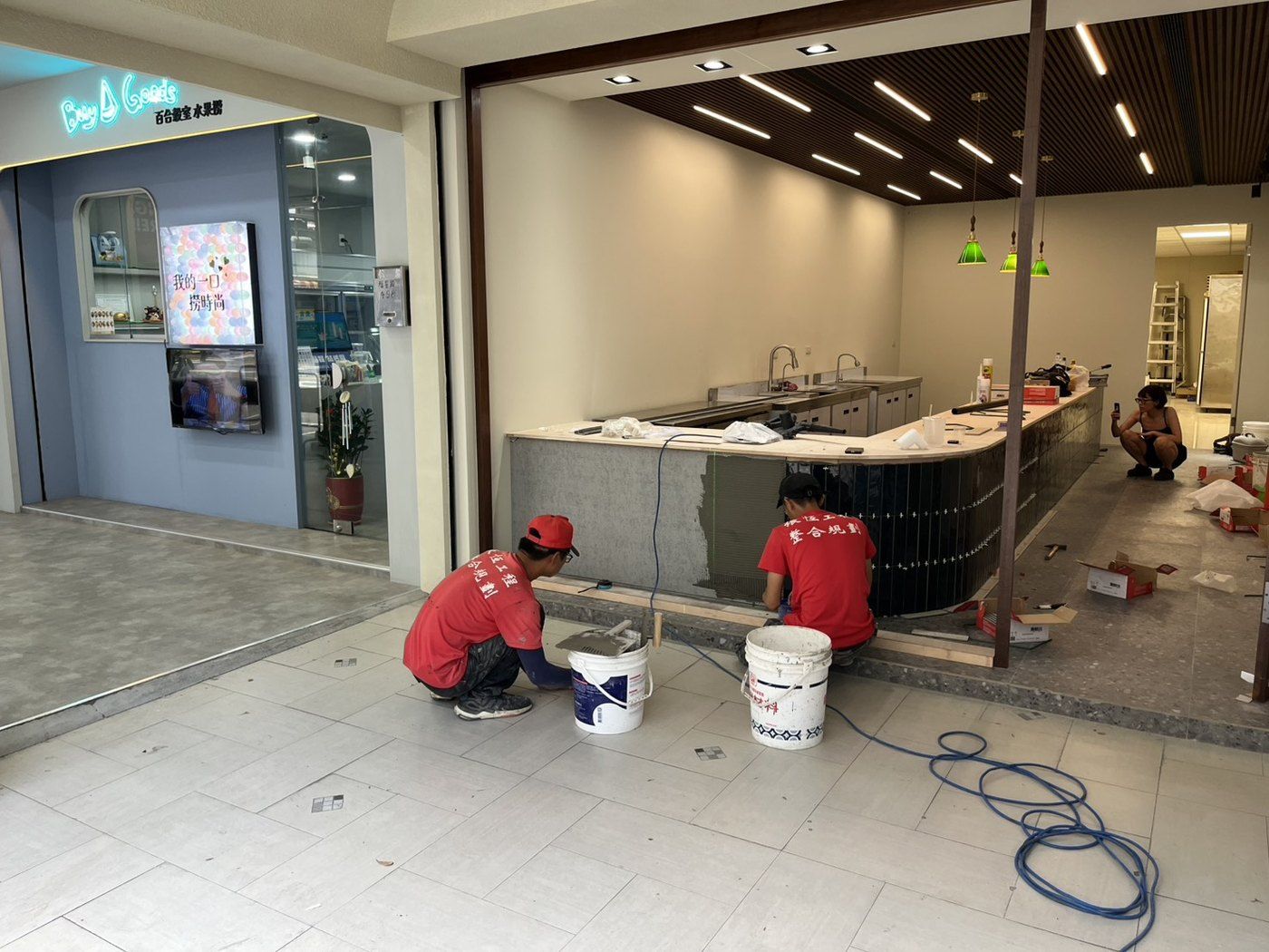 吧台立面貼綠色長條磚施工中。